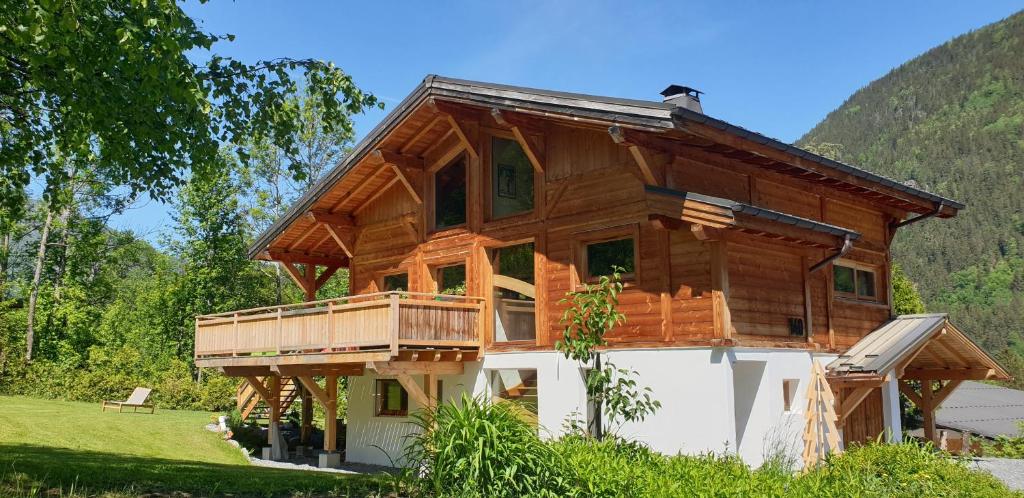 een blokhut met een veranda rondom en een terras bij Chalet CLADIE - Private Jacuzzi & Sauna - View of Mont Blanc range - By Cozee Rentals in Les Houches