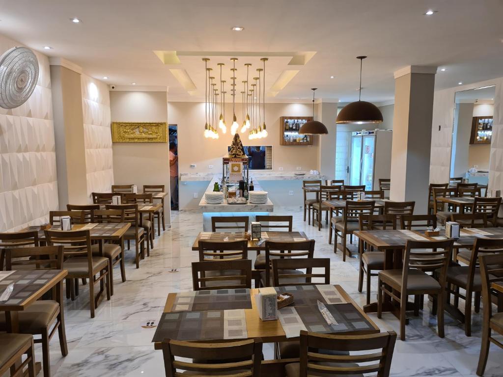 un restaurant rempli de tables et de chaises en bois dans l'établissement Princesa do Vale Hotel, à Aparecida