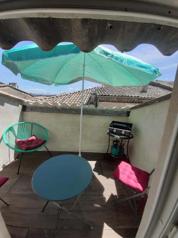 a table and chairs and an umbrella on a balcony at 4 Apt T2 50 à 60 M2 déplacement "PRO" ou "couple avec enfants" Les Hauts De Bourg " in Bourg-Saint-Andéol