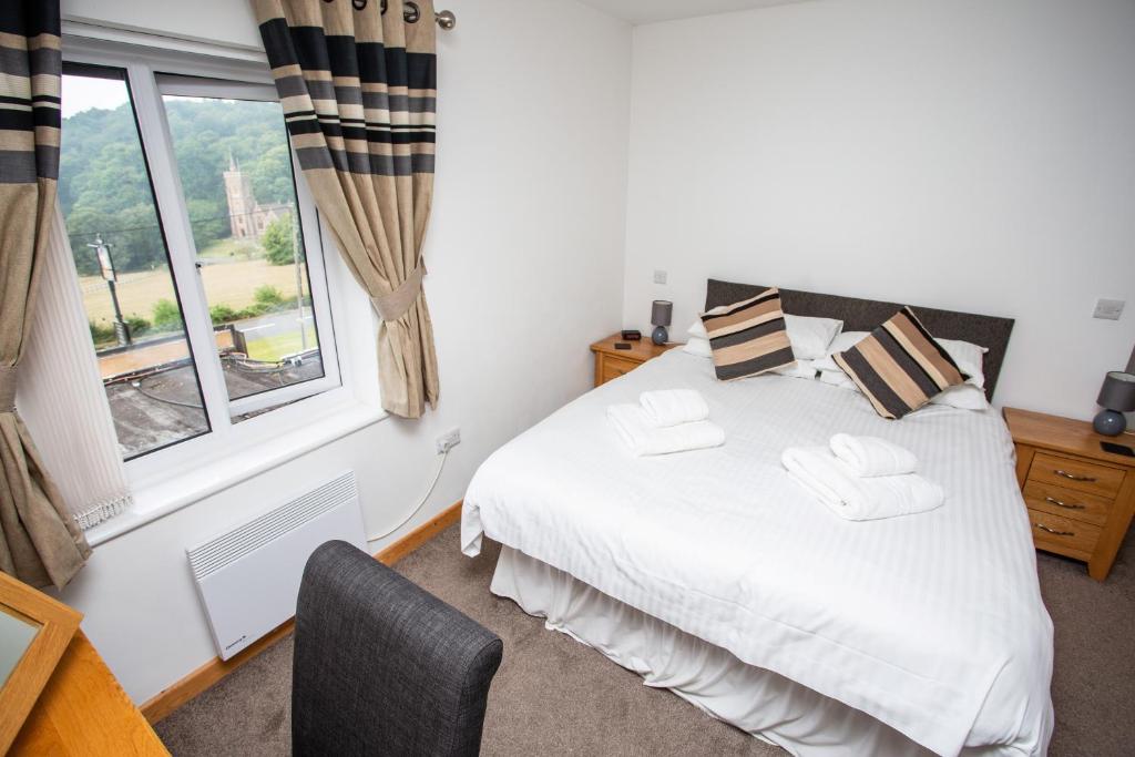 a bedroom with a white bed and a window at The Windmill Inn in Watchet