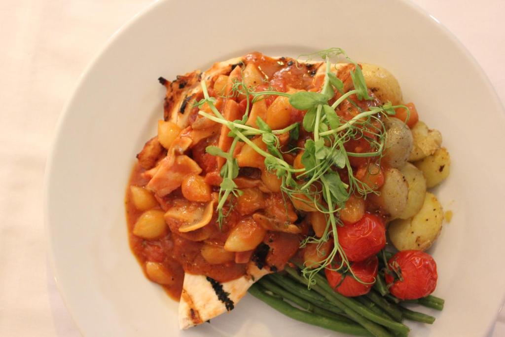 a white plate of food with beans and vegetables at The Windmill Inn in Watchet