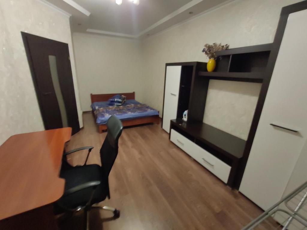 Cette chambre comprend un bureau, un lit, une table et des chaises. dans l'établissement Daily rent Apartments 5, à Ivano-Frankivsk
