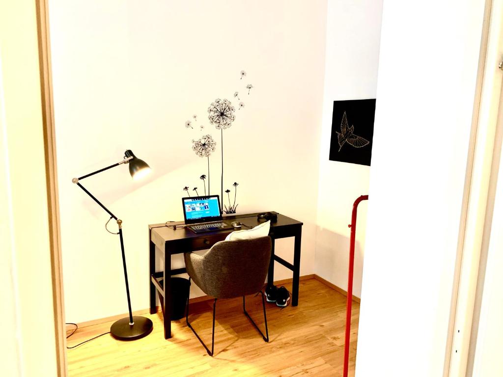 a desk with a laptop and a chair in a room at Urban City Retreat - by Nahuen Suites in Graz