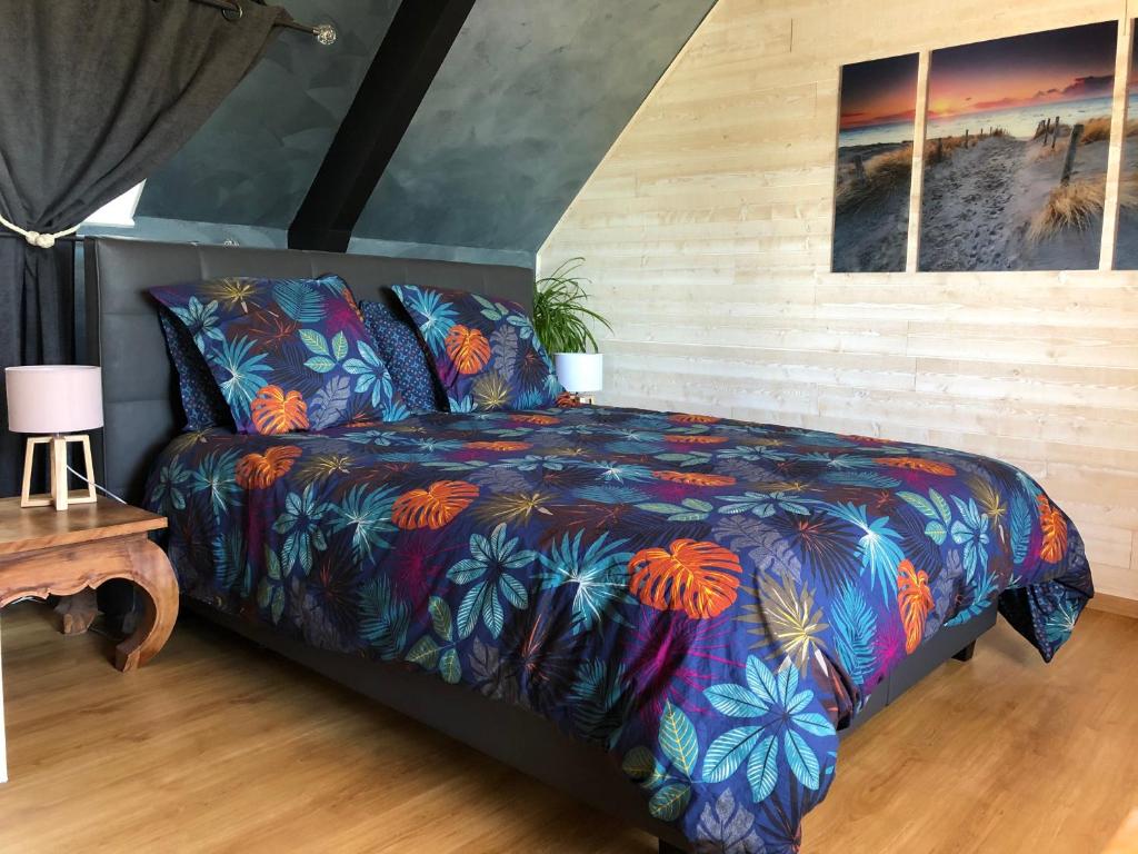 a bedroom with a bed with a colorful blanket at La Korrigane in Groix