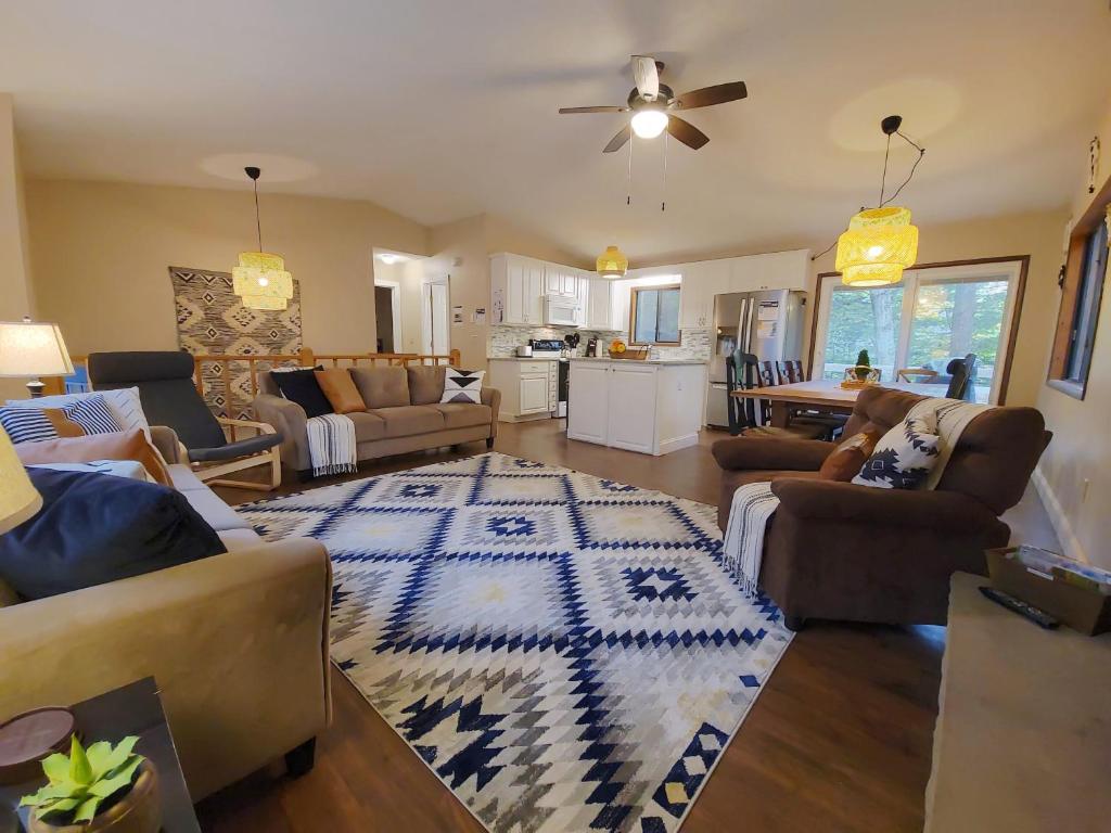 a living room with couches and a rug on the floor at Indoor Pool, Firepit, Self Check-in, BBQ, FREE Amenities, KING Bed, Full Kitchen in Lake Ariel