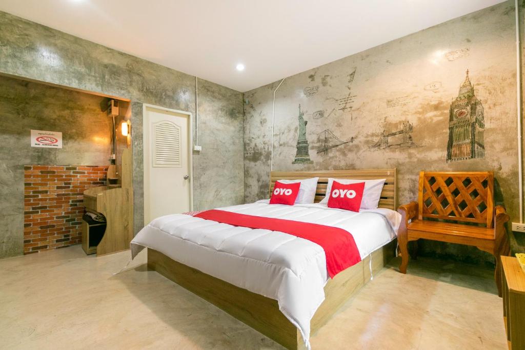 een slaapkamer met een groot bed met rode kussens bij OYO 945 The Rome Resort in Pran Buri