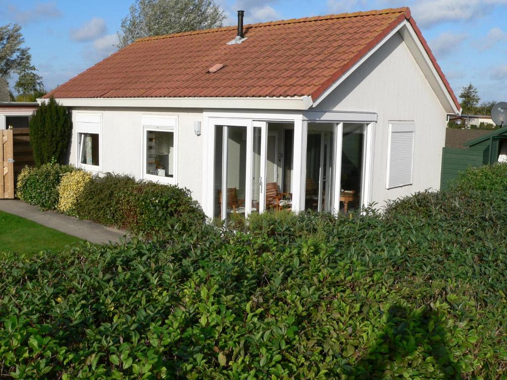 Casa blanca con techo rojo en Vakantiehuis Noord-Beveland kort bij de zee, en Colijnsplaat