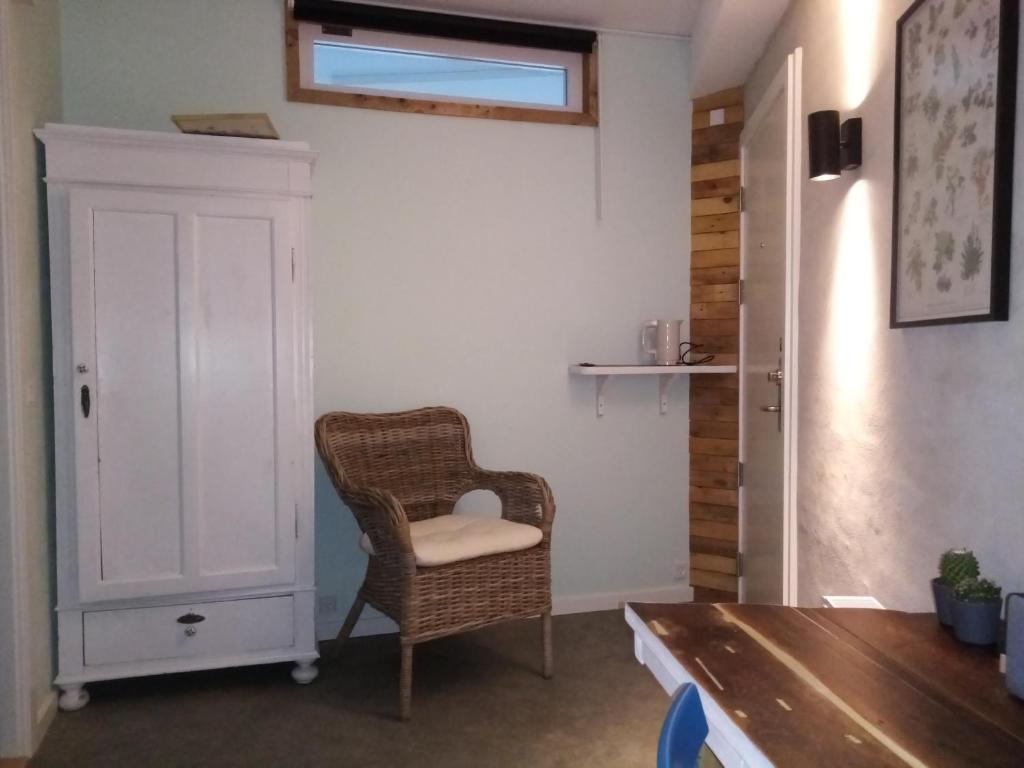 a room with a chair and a cabinet and a table at Samsted in Middelfart