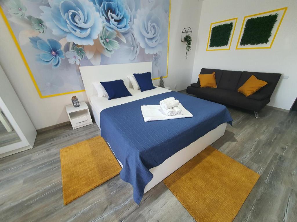 a bedroom with a bed and a couch at Garsoniera Argedava in Bucharest