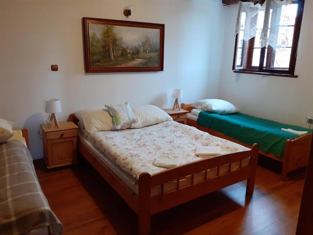 a bedroom with two beds and a painting on the wall at Apartament ogrodowy in Rydzewo
