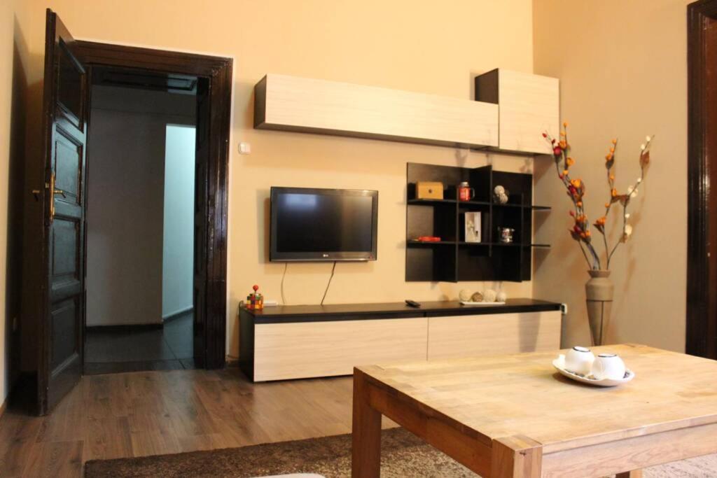 sala de estar con TV y mesa en Downtown central-apartment, en Oradea