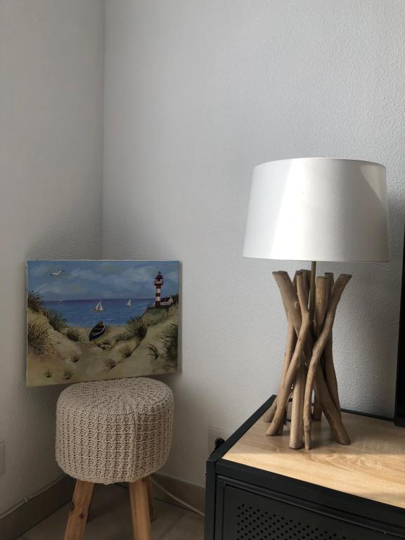 une lampe assise au-dessus d'une table à côté d'une chaise dans l'établissement LES MARINES 1 9217, à Dives-sur-Mer