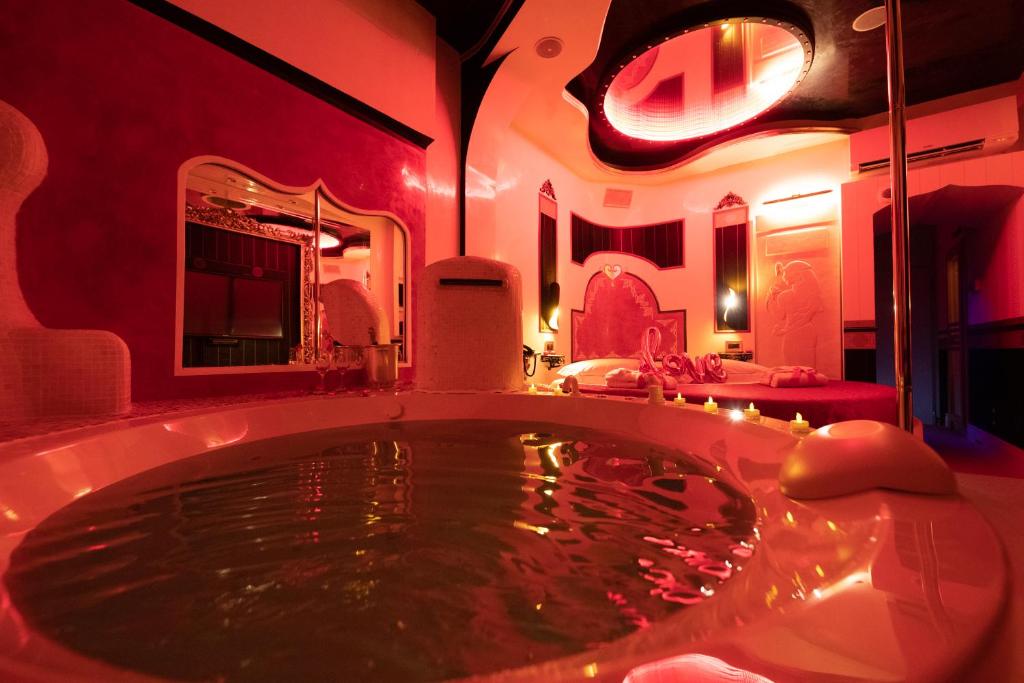 un ampio bagno con grande vasca con illuminazione rossa di Erossuite GuestHouse a Roma