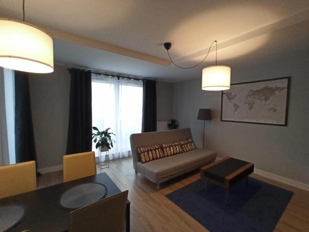 een woonkamer met een bank en een tafel bij Sun Apartment Katowice Chorzów in Katowice