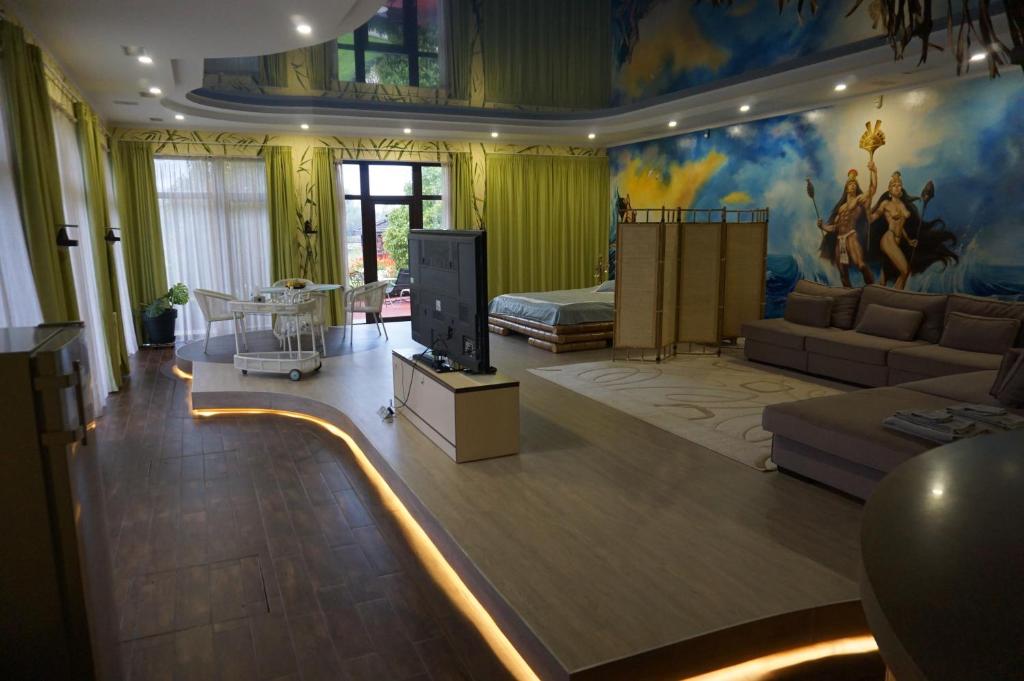 ein Wohnzimmer mit einem TV und einem Sofa in der Unterkunft Great accommodation for rest and relaxation! in Vishenki