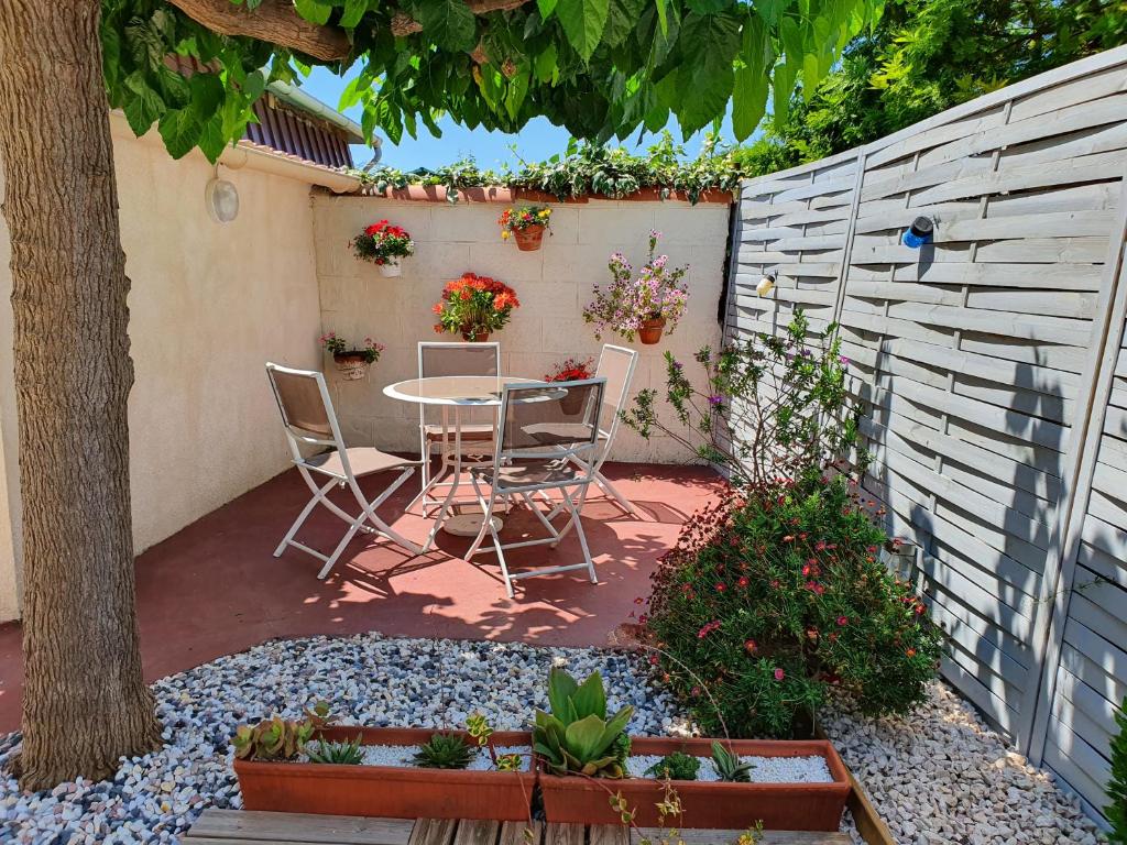 a patio with a table and chairs and a fence at Villa Dora in Frontignan
