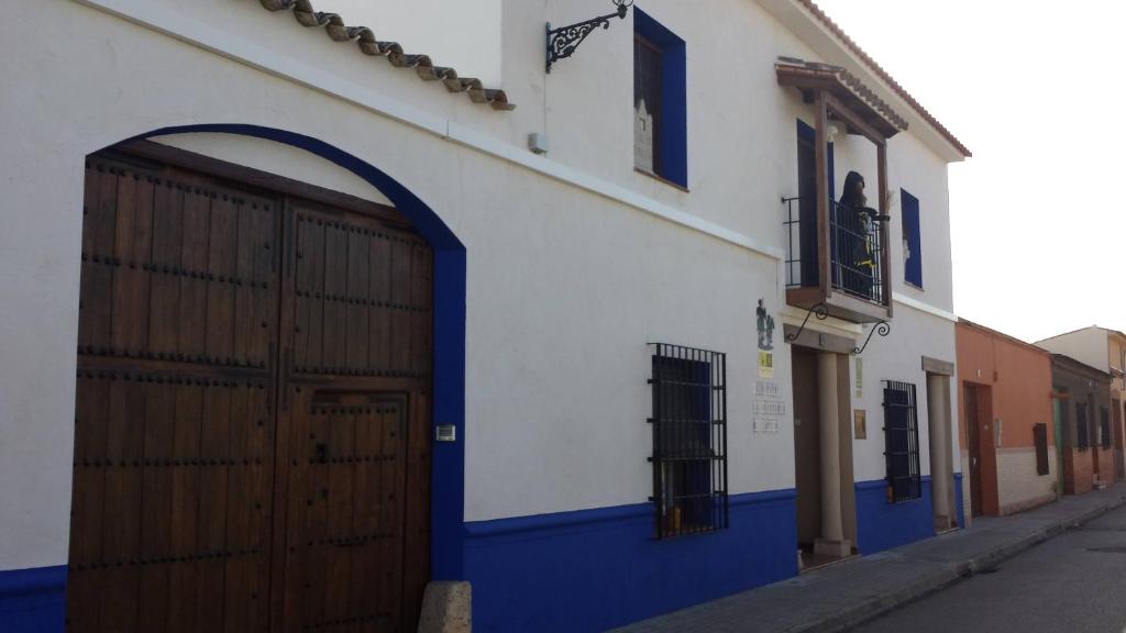 - un bâtiment bleu et blanc avec une grande porte dans l'établissement Hostal el lugar de la Mancha, à Argamasilla de Alba