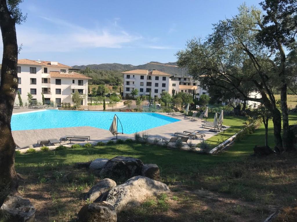 une grande piscine devant un immeuble dans l'établissement Résidence de Tourisme 5* Porto Vecchio, à Porto-Vecchio