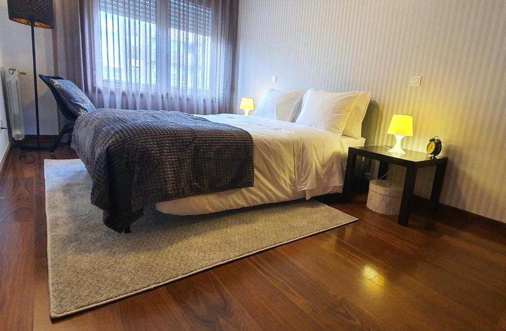 um quarto com uma cama grande e uma janela em VIVER D'AMOR Oporto Douro River Flat em Vila Nova de Gaia