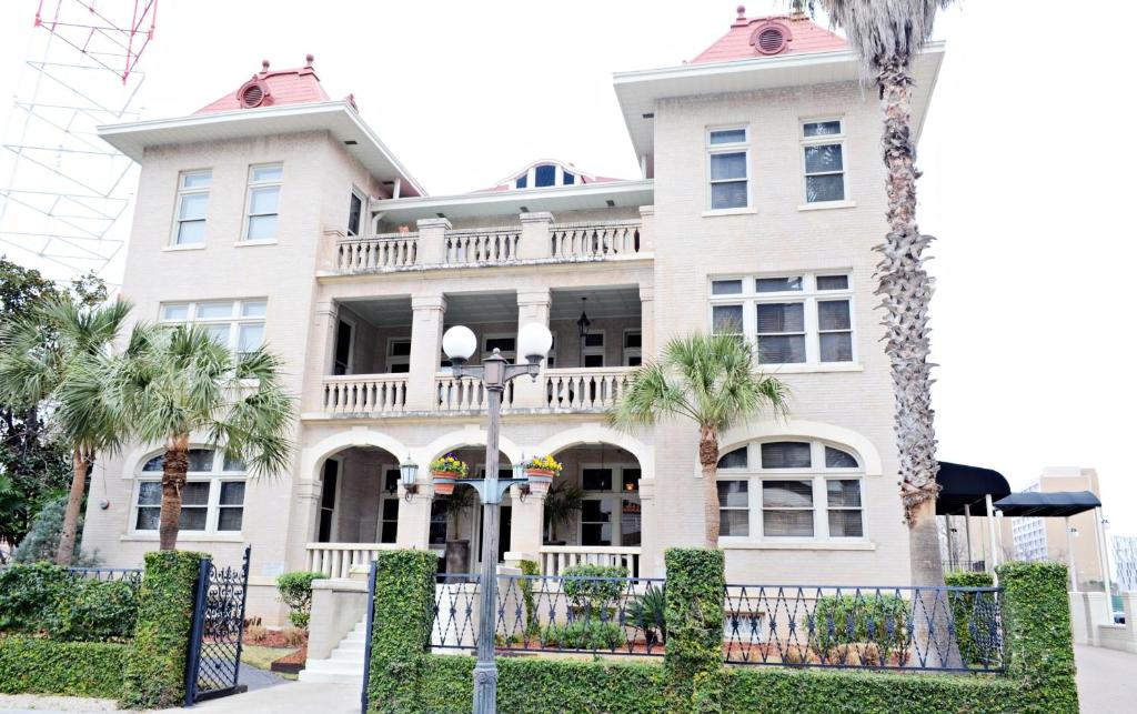 una gran casa blanca con palmeras delante en Hotel Havana, en San Antonio