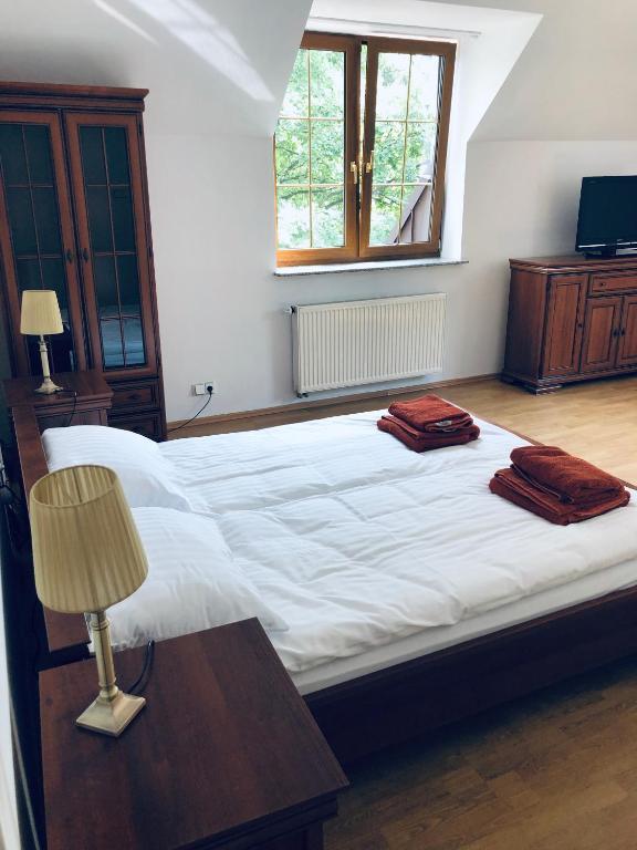 Podkowa Leśna的住宿－Apartament Plumeria w Podkowie Leśnej，一间卧室配有一张大床和两条毛巾