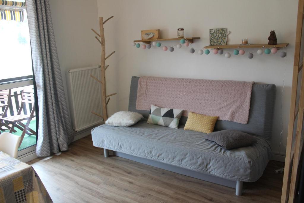 uma sala de estar com um sofá com almofadas em SUPERDEVOLUY STUDIO au 433S em Le Dévoluy