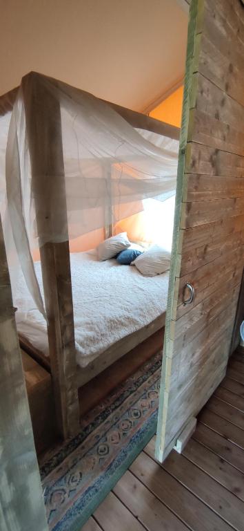 a bedroom with a bed inside of a tent at Le Relais d'Artagnan - relais équestre in Mortier