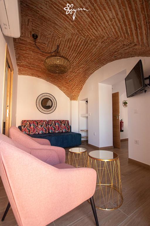 een woonkamer met een bank en tafels bij Apartamentos Turísticos AbrilyMarzo in Cáceres