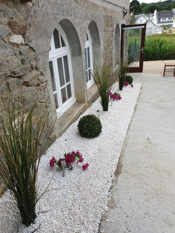 un jardin avec des fleurs devant un immeuble dans l'établissement Ty Keramor, à Hôpital-Camfrout
