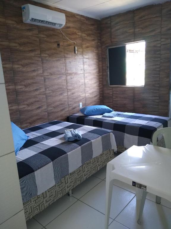 two beds in a room with a flat screen tv at HOTEL CIDADE EXPRESS 24H in Teresina
