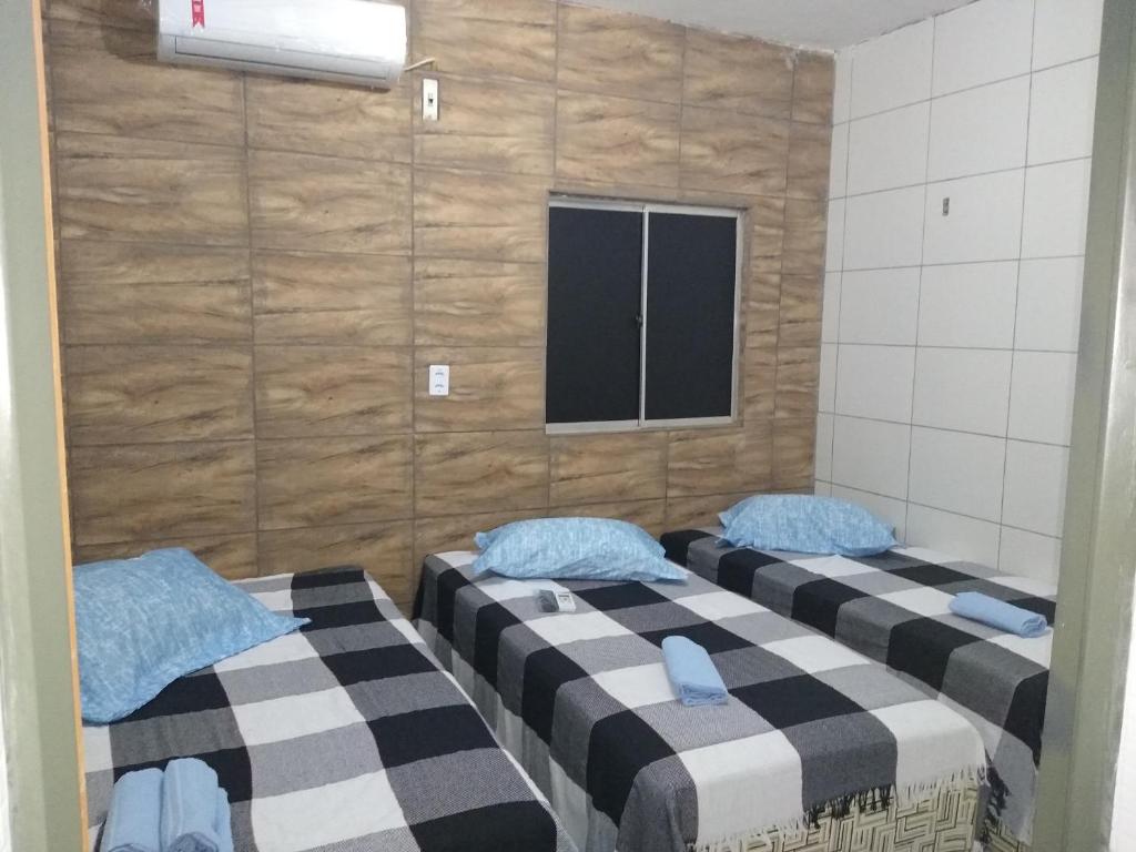 two beds in a room with a window at HOTEL CIDADE EXPRESS 24H in Teresina