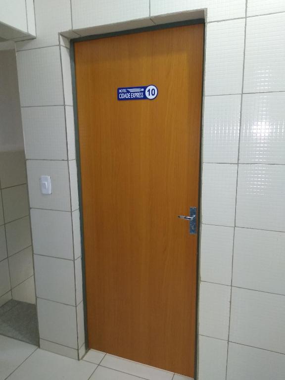 a wooden door with a sticker on it in a bathroom at HOTEL CIDADE EXPRESS 24H in Teresina