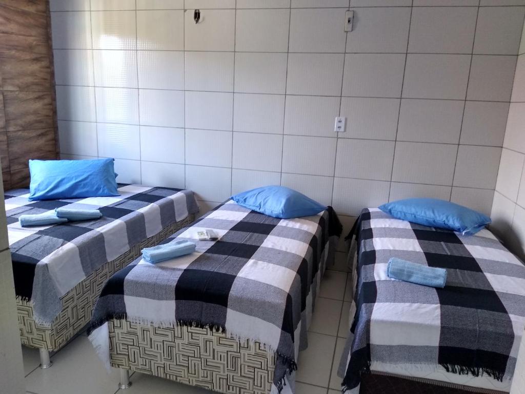 two beds in a room with blue pillows at HOTEL CIDADE EXPRESS 24H in Teresina