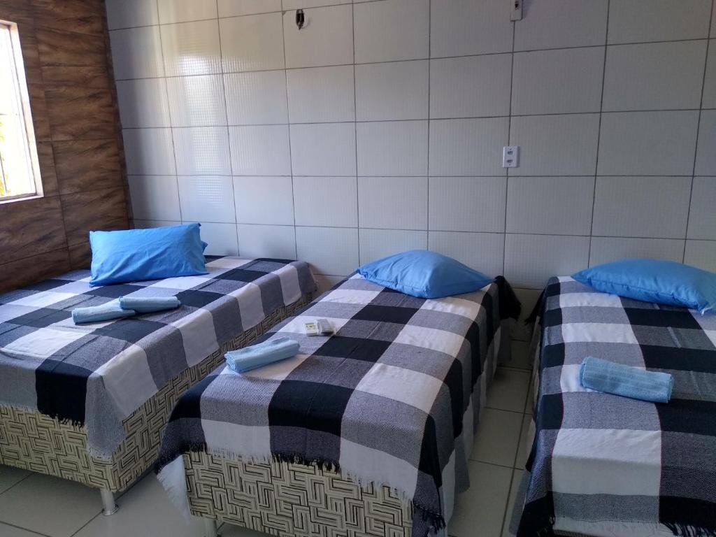 two beds in a room with blue pillows at HOTEL CIDADE EXPRESS 24H in Teresina