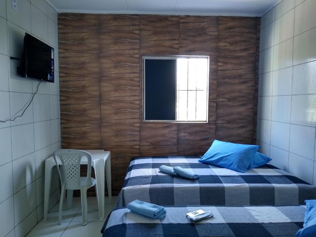 a bedroom with two beds and a chair and a window at HOTEL CIDADE EXPRESS 24H in Teresina