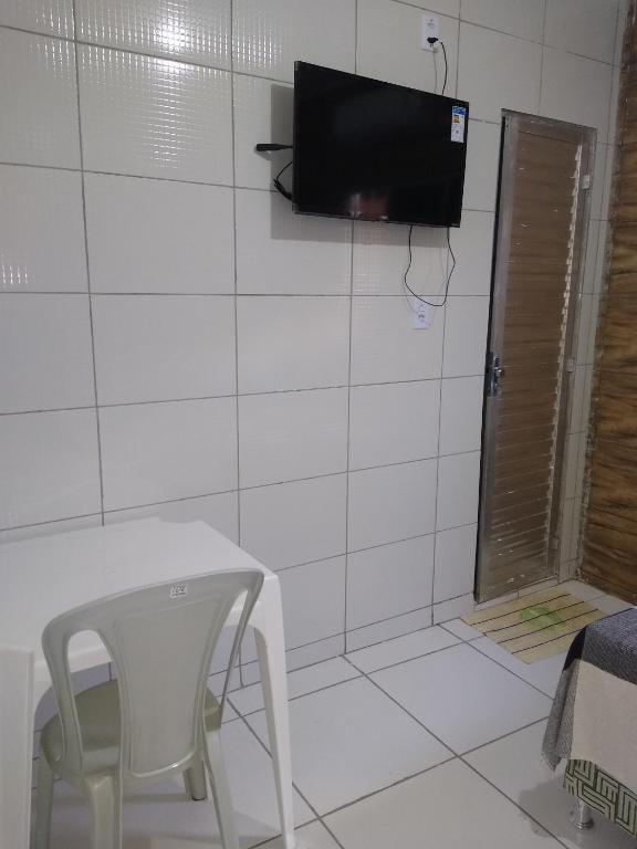 a white table and a chair and a tv on a wall at HOTEL CIDADE EXPRESS 24H in Teresina