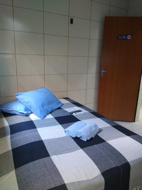 a bedroom with a bed with blue pillows and a door at HOTEL CIDADE EXPRESS 24H in Teresina