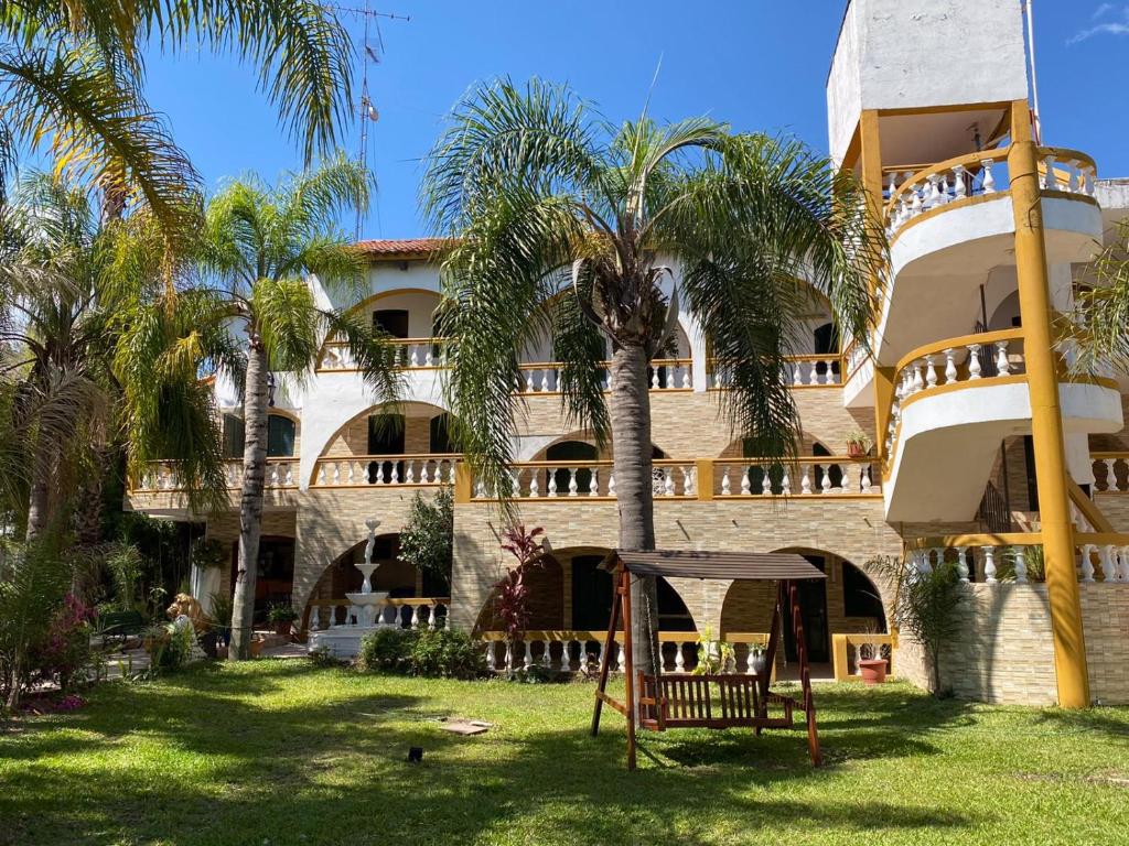 a building with palm trees in front of it at Casablanca Termal Apart-Hotel in Termas del Daymán