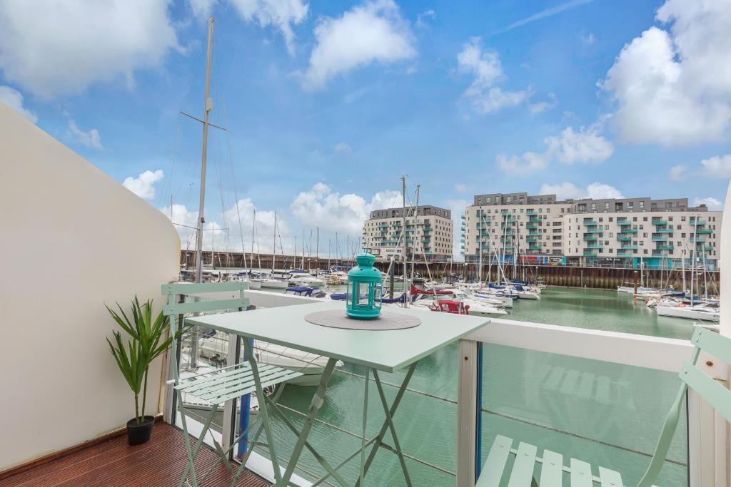 a balcony with a table and boats in a marina at On the Water 2 with Free Parking - By My Getaways in Brighton & Hove