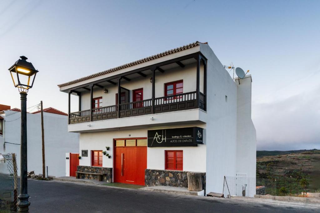 un edificio blanco con puertas rojas y luz de la calle en La Hoya del Cura, en Valle Gran Rey