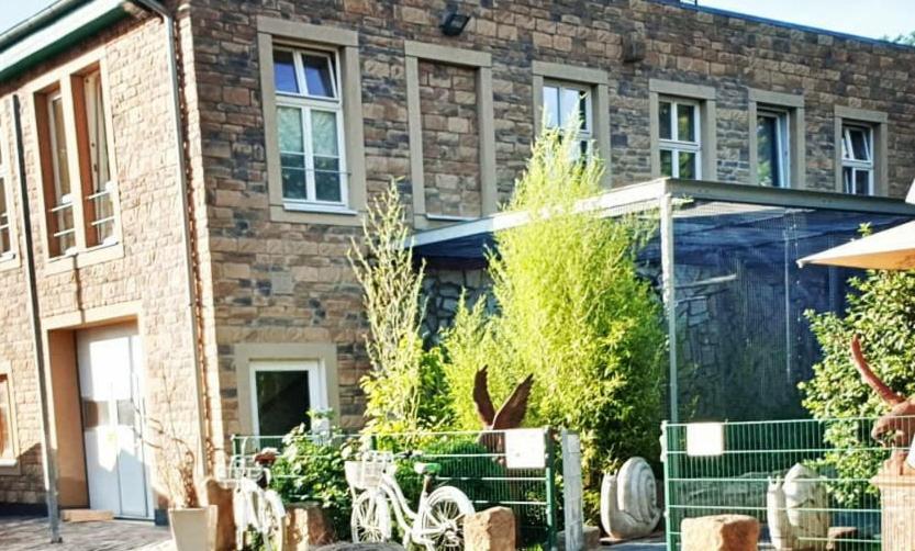 ein Backsteinhaus mit einer Terrasse mit Stühlen davor in der Unterkunft Papageiennest in Dresden