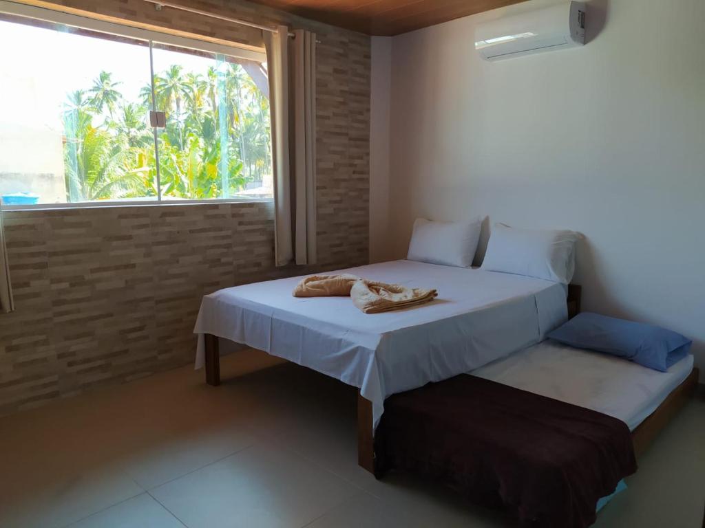 a bedroom with a bed with towels on it at POUSADA ESTALAGEM BOM JESUS in São Miguel dos Milagres