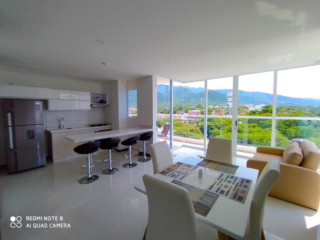una cucina con tavolo e sedie e una grande finestra di Apartamento en Santa Marta, hermosa vista. a Santa Marta