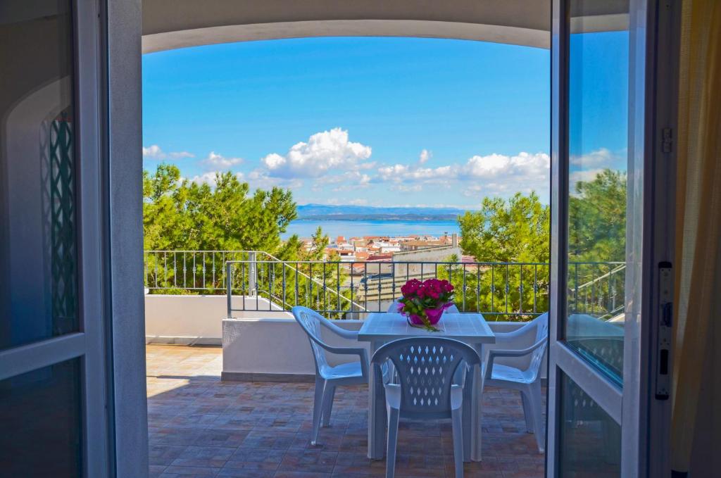 uma mesa e cadeiras numa varanda com vista para o oceano em Residence Fior di Sulcis em Calasetta