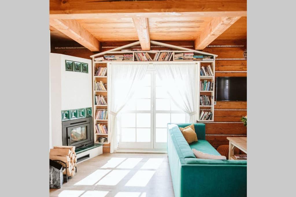 a living room with a blue couch and a fireplace at Kolíska pokoja in Osturňa