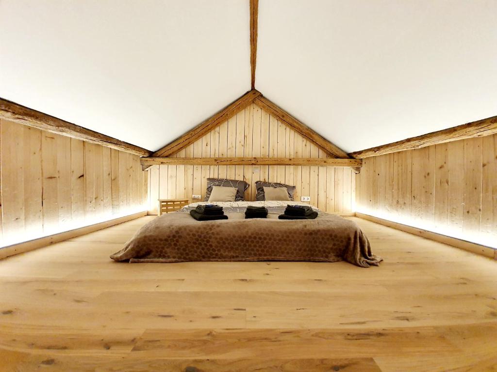 sypialnia z dużym łóżkiem w pokoju z drewnianymi ścianami w obiekcie Sam's Cottage Suite w mieście Niederweis