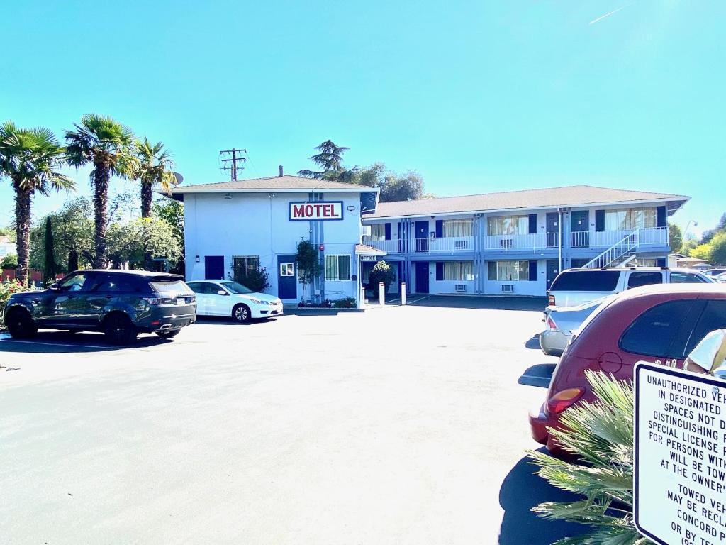 a hotel with cars parked in a parking lot at Valley Motel in Concord