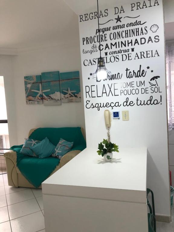 uma sala de estar com um sofá e um balcão branco em Apartamento Peracanga com Wi-Fi em Guarapari