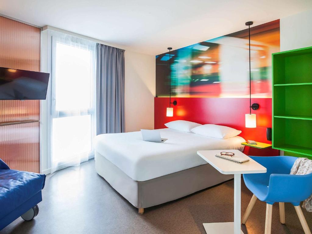 ミュルーズにあるIbis Styles Mulhouse Centre Gareのベッドルーム(白いベッド1台、青い椅子付)