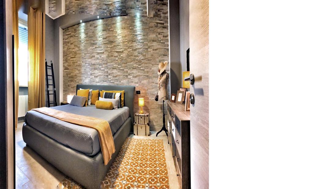 um quarto com uma cama e uma parede de tijolos em Appartamento La Paleologa em Casale Monferrato
